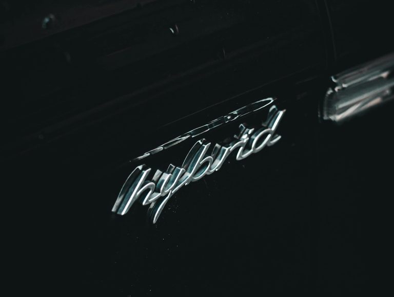 A chrome hybrid symbol on a car.